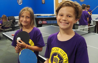 Kids playing table tennis at day camp