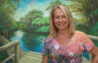 April Davis in front of her art